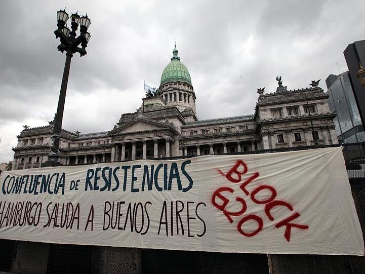"Zusammenschluss von Widerständen. Hamburg lässt Buenos Aires grüssen. Block G20" steht auf einem Plakat vor dem argentinischen Kongress in Buenos Aires.