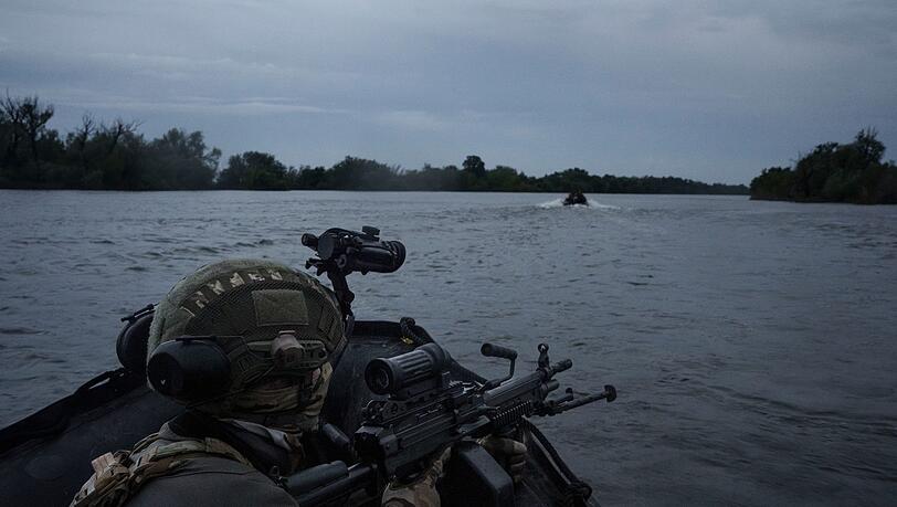 Ukrainische Soldaten fahren mit einem Boot auf dem Fluss Dnipro an der Frontlinie in der Nähe von Cherson.