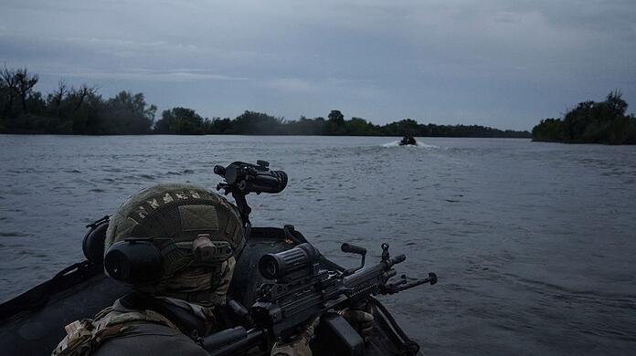 Ukrainische Soldaten fahren mit einem Boot auf dem Fluss Dnipro an der Frontlinie in der Nähe von Cherson.