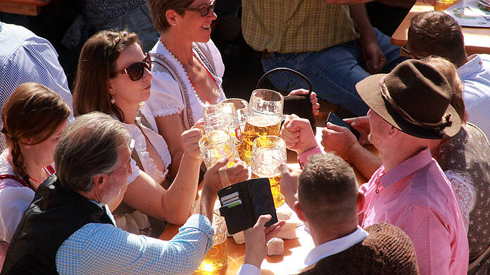 Oktoberfest 2019: Besucher prosten sich im Biergarten der Ochsenbraterei mit ihren Maßkrügen zu.