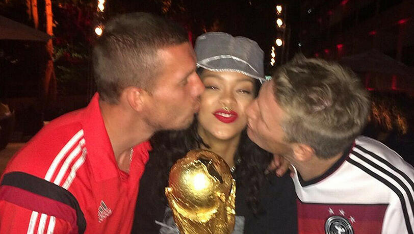 Freut sie sich über den Pokal oder die Küsse: Rihanna zwischen Lukas Podolski (l.) und Bastian Schweinsteiger Freut sie sich über den Pokal oder die Küsse: Rihanna zwischen Lukas Podolski (l.) und Bastian Schweinsteiger