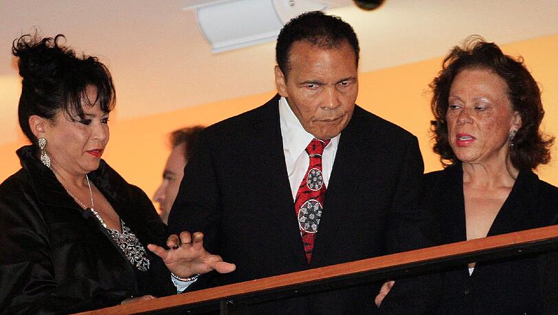 Vom Parkinson gezeichnet nahm Muhammad Ali in Louisville, gestützt von seiner Frau Lonnie (re.) und seiner Schwägerin Marilyn Williams, an seiner Geburtstagsfeier teil. Vom Parkinson gezeichnet nahm Muhammad Ali in Louisville, gestützt von seiner Frau Lonnie (re.) und seiner Schwägerin Marilyn Williams, an seiner Geburtstagsfeier teil.