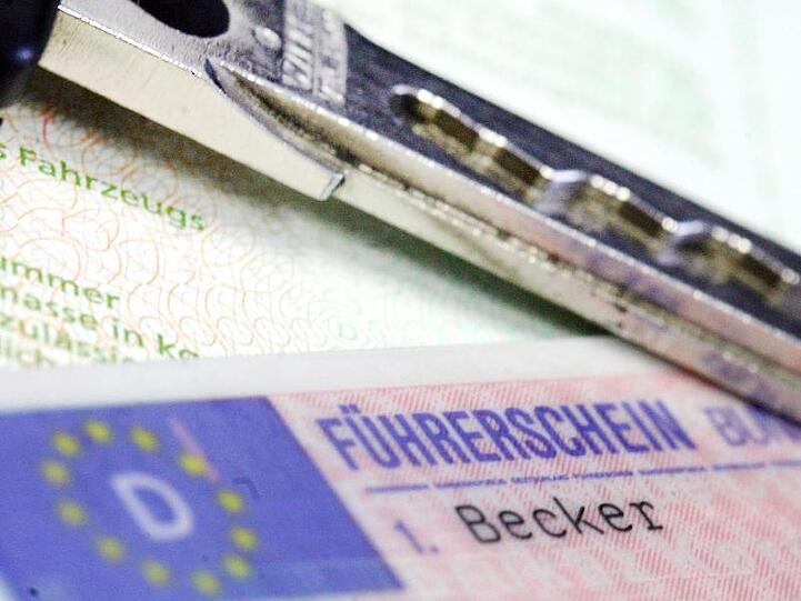 Führerschein und Autoschlüssel liegen auf einem Fahrzeugschein. Foto: Marius Becker/dpa/Symbolbild