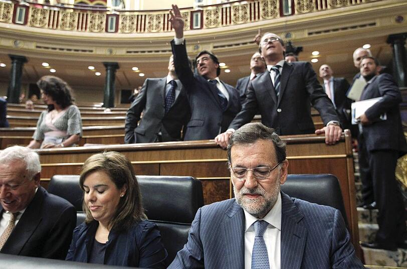 Ministerpräsident Mariano Rajoy (vorne rechts) nimmt's auf der Kabinettsbank mit unbewegter Miene hin.