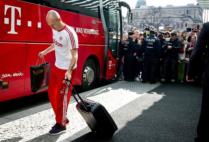Müde Bayern-Spieler schleppen sich nach einer kurzen Nacht zum Mannschaftsbus.
