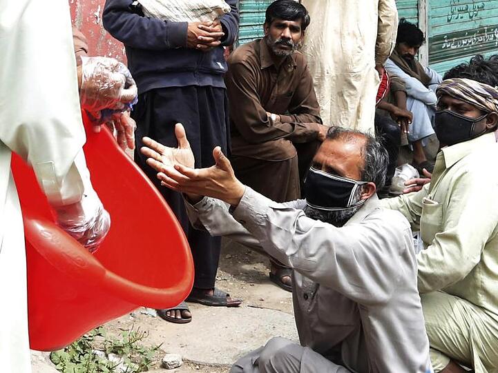 Freiwillige Helfer verteilen Lebensmittel an Tagelöhner im pakistanischen Lahore.