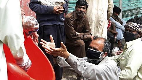 Freiwillige Helfer verteilen Lebensmittel an Tagelöhner im pakistanischen Lahore.