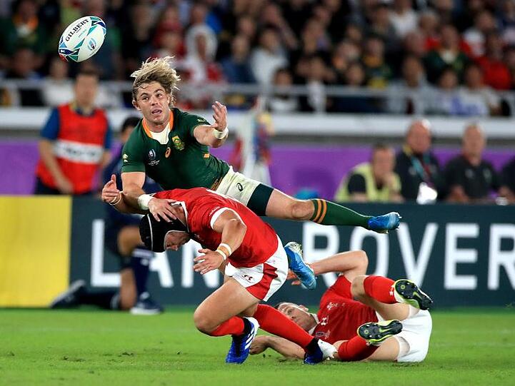 Südafrikas Faf de Klerk (oben) im Duell mit den Walisern Leigh Halfpenny (l) und Gareth Davies.