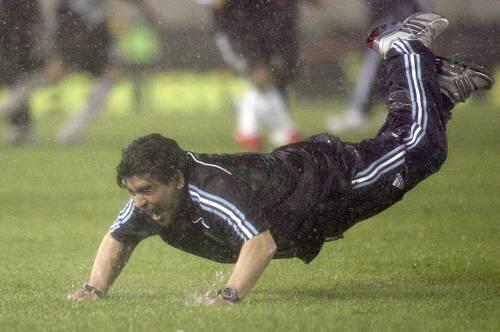 Selbst das schlimmste Wetter kann Diego Maradonas Laune nicht trüben. Argentiniens Coach zeigt beim Freudensprung, dass sein Bauch durchaus belastbar ist.