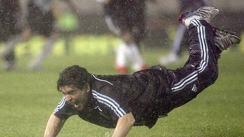Selbst das schlimmste Wetter kann Diego Maradonas Laune nicht trüben. Argentiniens Coach zeigt beim Freudensprung, dass sein Bauch durchaus belastbar ist.