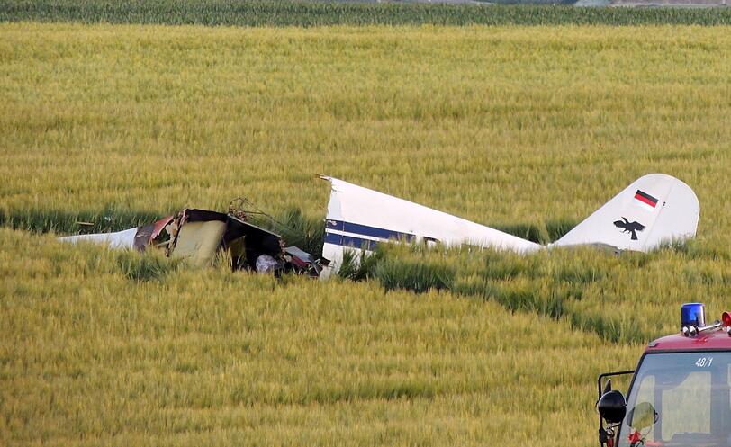 Polizisten stehen in einem Feld bei einem abgestürzten Sportflugzeug am 23.05.2014 bei Egweil. Der Pilot und seine beiden Passagiere sind bei dem Absturz der einmotorigen Klemm D107 eines Neuburger Sportflugvereins und ums Leben gekommen.