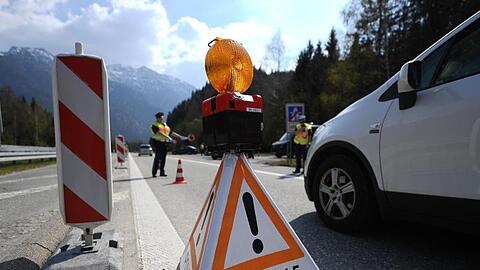 Polizisten kontrollieren am Autobahnende der A95 Richtung Süden Fahrzeuge. Foto: Angelika Warmuth/dpa