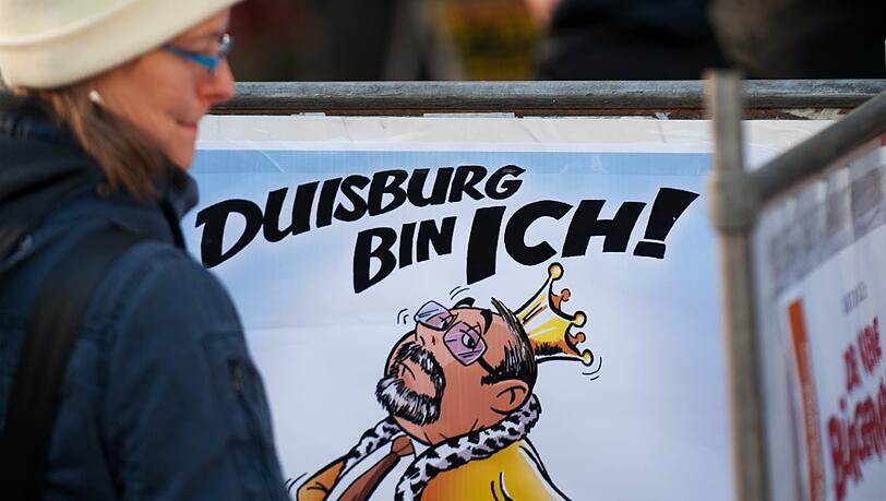 Passanten betrachten am Donnerstag in Duisburg eine Karikatur des Kuenstlers Martin Tazl vom Oberbuergermeister von Duisburg, Adolf Sauerland (CDU), mit der Ueberschrift "Duisburg bin ich!" und der Unterschrift "Nicht mehr lange!!!" Passanten betrachten am Donnerstag in Duisburg eine Karikatur des Kuenstlers Martin Tazl vom Oberbuergermeister von Duisburg, Adolf Sauerland (CDU), mit der Ueberschrift "Duisburg bin ich!" und der Unterschrift "Nicht mehr lange!!!"