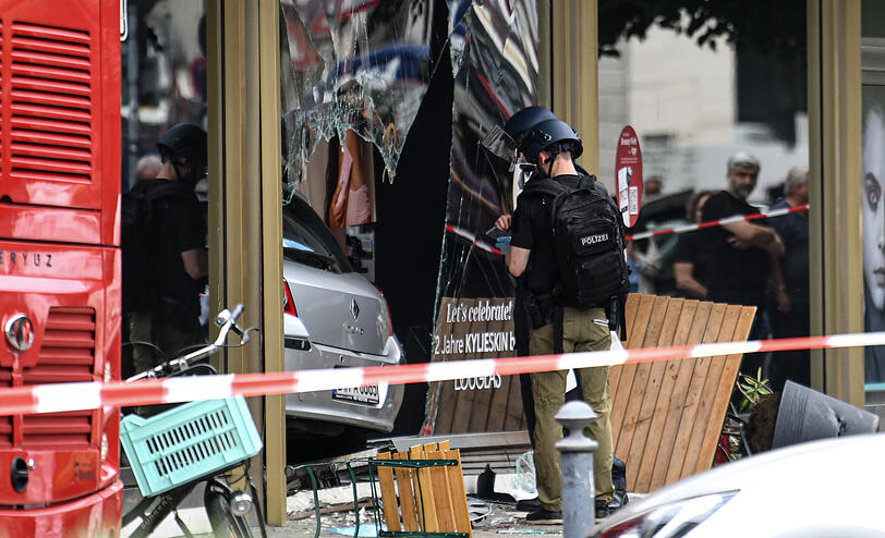 Die Polizei sichert Spuren an dem zerbrochenen Schaufenster des Douglas-Geschäftes, in das das Auto gefahren ist.