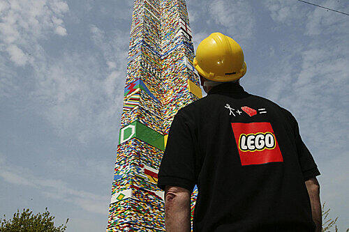 Ein Mitarbeiter von Lego bewundert einen riesigen Klotz-Turm