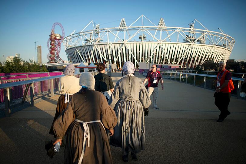 Statistinnen in historischen Gewändern auf dem Weg zur Generalprobe für die Eröffnungsfeier der Olympischen Spiele 2012 in London