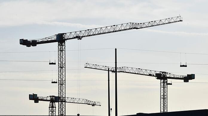 Kräne stehen auf einer Baustelle.