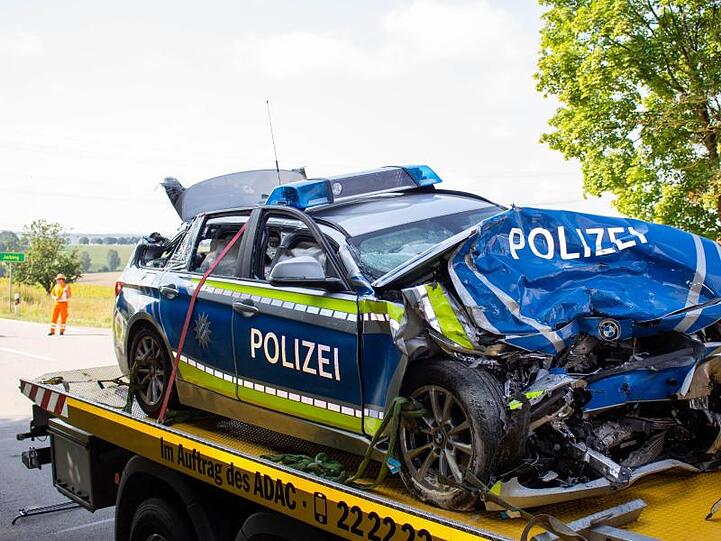 Ein ramponierter Polizeiwagen steht nach einem Unfall auf einem Abschleppwagen. Foto: Schmelzer/NEWS5
