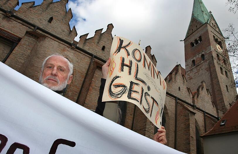 Katholiken stehen am Samstag (21.04.2012) mit Transparenten auf dem Domplatz von Augsburg (Schwaben). Im Rahmen einer Kundgebung demonstrieren sie gegen die geplante Pastoralreform des Bistums Augsburg.