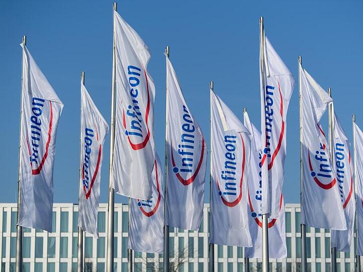 Flaggen mit dem Logo von Infineon flattern im Wind. Foto: Matthias Balk/Archiv
