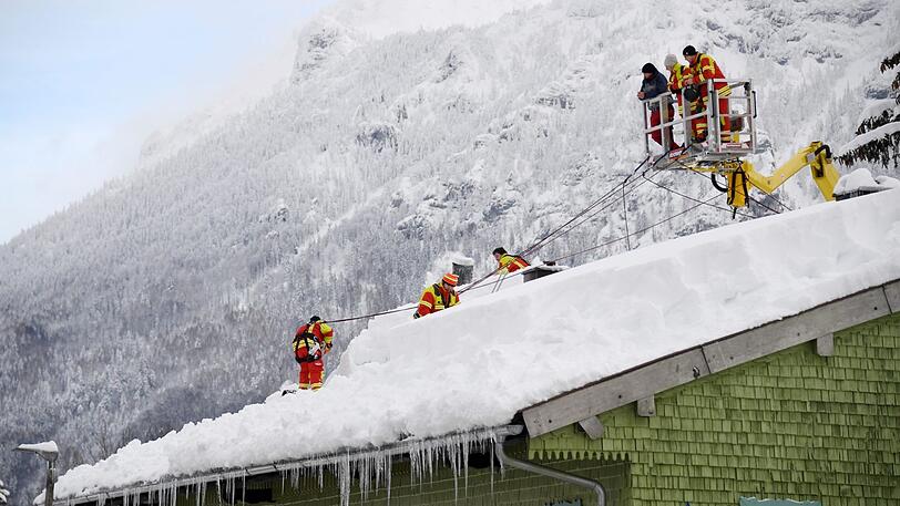 Januar 2019 in Inzell: Feuerwehrleute räumen den Schnee vom Dach eines Hauses.