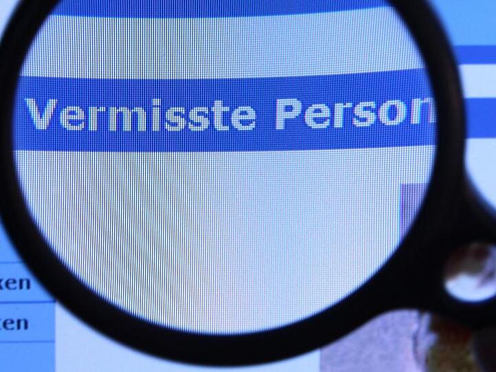 Hinter einer Lupe ist der Schriftzug "Vermisste Person" zu sehen. Foto: Jens Büttner/ZB/Archiv