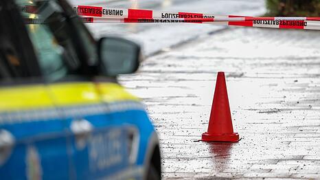 Polizeibeamte bewachen in einem Streifenwagen den Tatort.