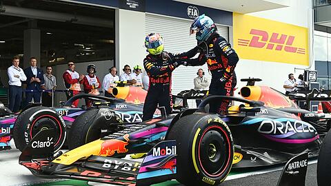 Red-Bull-Pilot Sergio Pérez (l) gratuliert seinem Teamkollegen Max Verstappen zum Sieg.