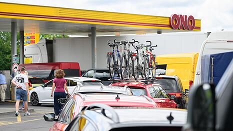 Autofahrer stehen an einer Tankstelle in der Schlange, um zu tanken. (Archivbild)