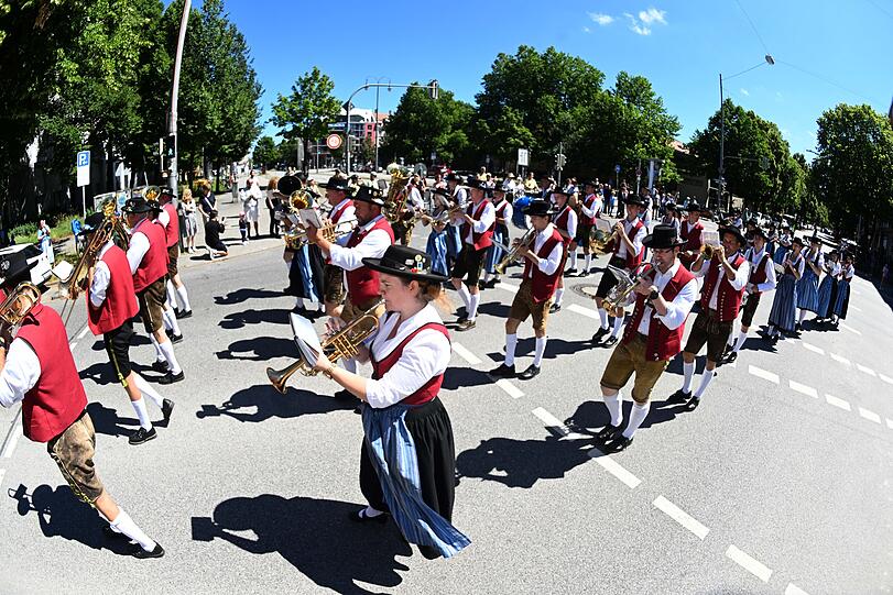 02.07.2022, Bayern, München: Eine Trachtenkapelle lauft bei einer Parade im Rahmen des Festivals des Spiels, des Sports und der Kunst zum 50-jährigen Jubiläum der Olympischen Spiele in München durch die Straßen.