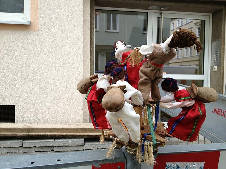 - ein Puppenreigen tanzt für aufmerksame Beobachter auf dem Bauzaun.