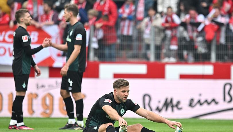 Bremens Niclas Füllkrug sitzt nach Spielende auf dem Mainzer Rasen.