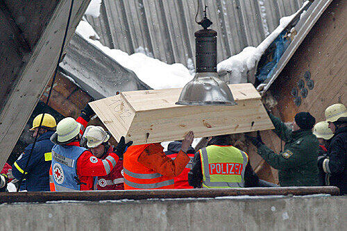 Helfer decken am 4. Januar 2006 in der eingestürtzten Eissporthalle in Bad Reichenhall den Sarg eines soeben gefundenen Verschütteten ab.