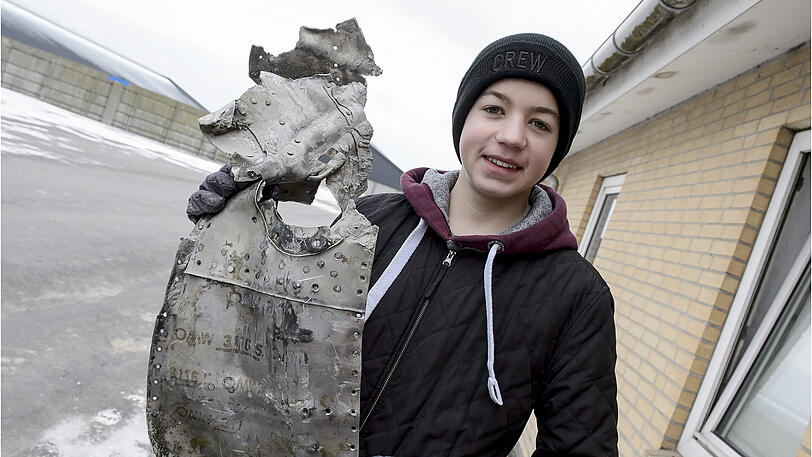 Rom Kristiansen (14) mit einem Wrackteil des Flugzeugs.