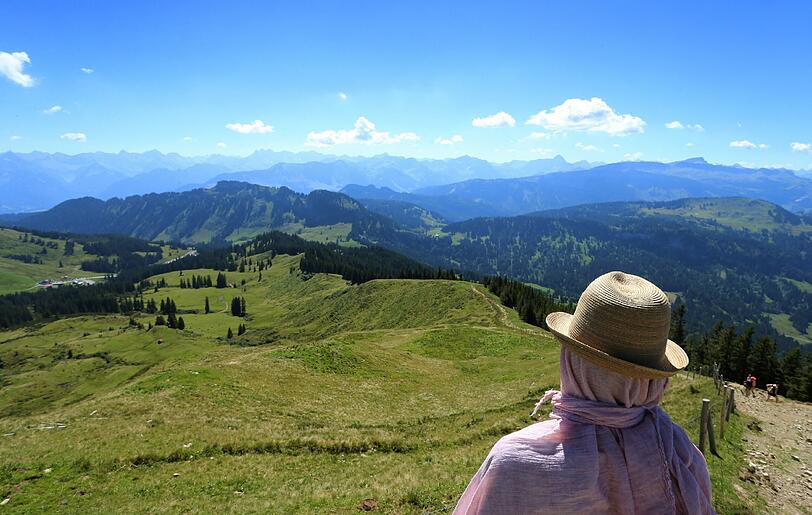 Ein Wanderer schaut nahe des Gipfels vom Riedberger Horn in Richtung des Skigebietes Grasgehren bei Obermaiselstein.
