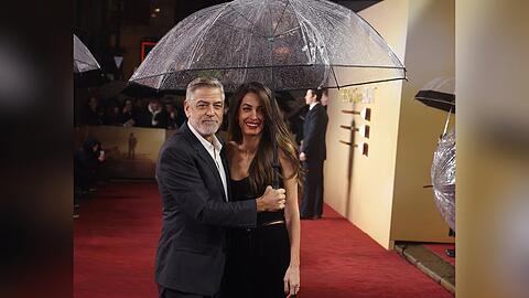 George und Amal Clooney mit Regenschirm in London.