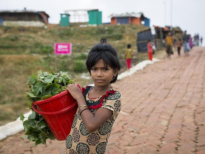 Ein Rohingya-Mädchen trägt Gemüse zum Markt eines Flüchtlingslagers, um es dort zu verkaufen.