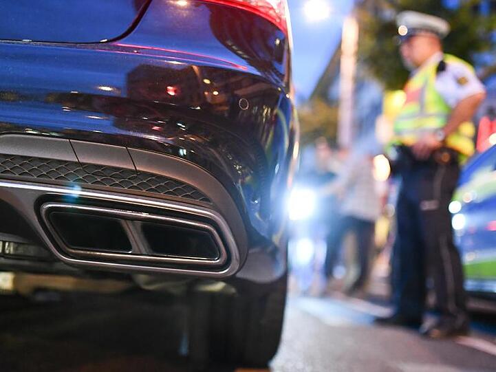 Polizeibeamte kontrollieren sogenannte Autoposer. Foto: Uwe Anspach/dpa/Symbolbild