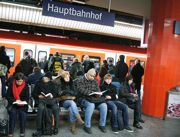 Sie haben sich etwas zu lesen mitgebracht: Die meisten Fahrgäste, die auf ihre Züge warten müssen, tragen die Verzögerungen mit Fassung.