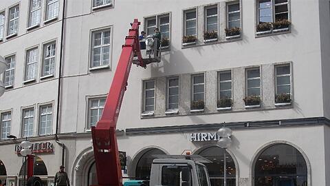 Die Adventsdeko am Modehaus Hirmer wird ausgetauscht gegen frische Frühlimgsblumen