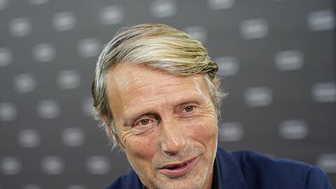 Schauspieler Mads Mikkelsen steht auf dem Roten Teppich.
