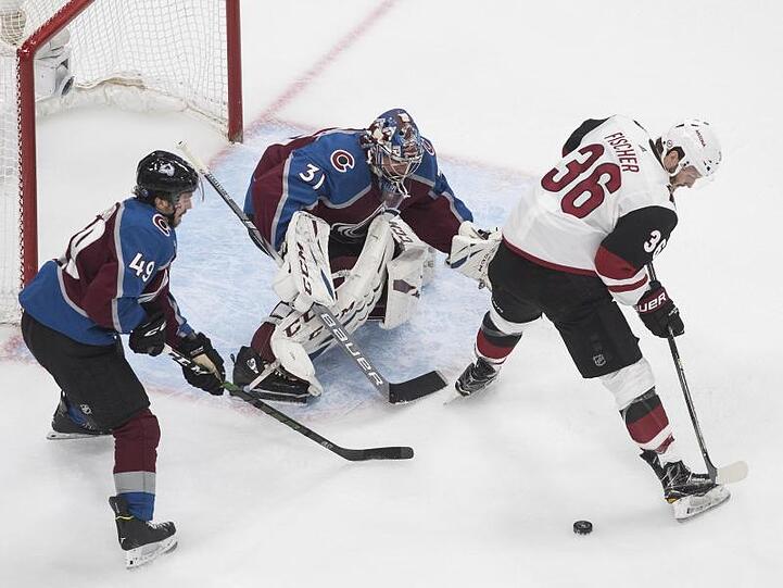 Avalanche-Torhüter Philipp Grubauer (M) verteidigt mit Samuel Girard (l) den Kasten gegen Christian Fischer.