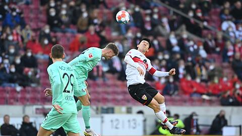 Bochums Patrick Osterhagey (m) kämpft mit Stuttgarts Wataru Endo (r) um den Ball.