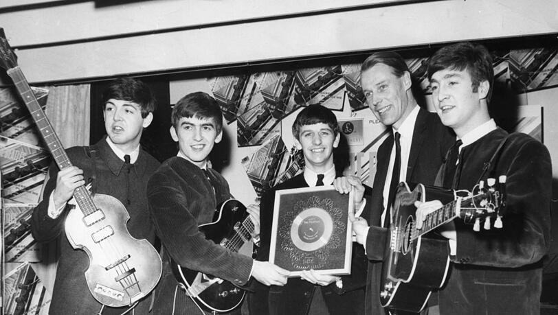 Paul McCartney (links), George Harrison, Ringo Starr, Produzent und „fünter Beatle“ George Martin und John Lennon, im August 1963 mit einer silbernen Schallplatte für 250.000 verkaufte Alben. Es wurden dann noch viele mehr.