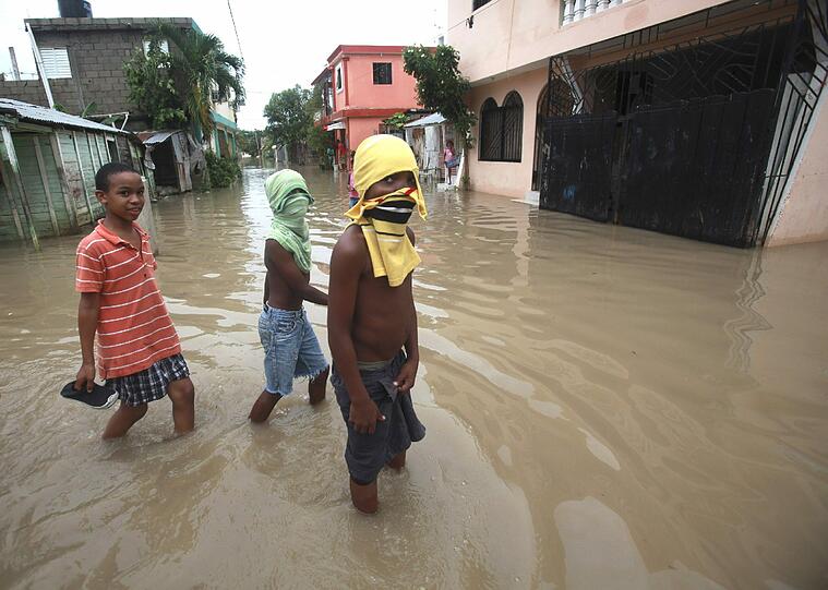 Es stinkt: Das Wasser ist voller Bakterien. Diese drei Jungs schützen sich mit Schals vor dem Gestank.