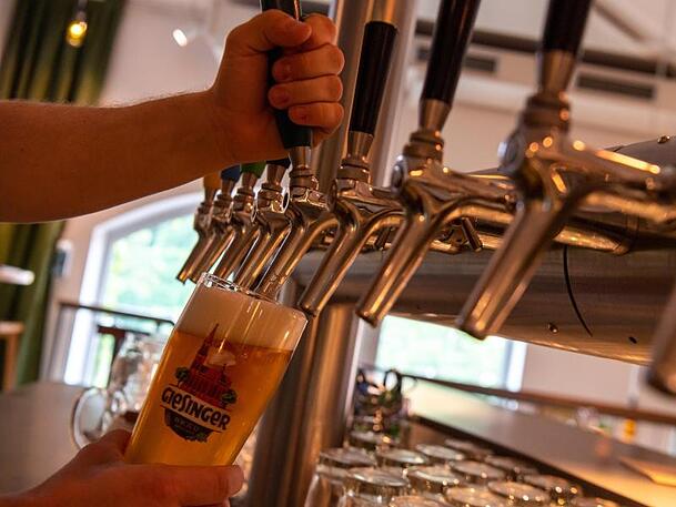 Ein Glas wird im Lokal der Giesinger Bier-Brauerei mit Bier gezapft. Noch immer gäbe es Skeptiker, die seit Generationen das gleiche Bier trinken. Die möchte Moses Wolff vom Bier überzeugen.