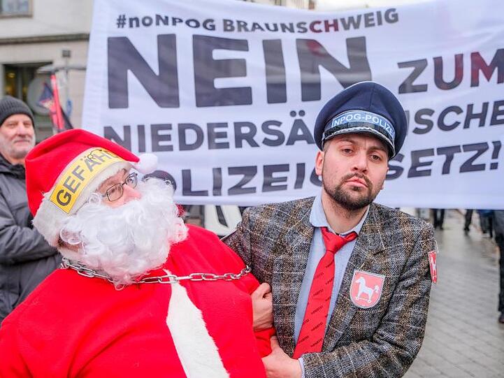 Als Weihnachtsmann und Polizist verkleidet protestieren Teilnehmer des Demonstrationszug gegen das geplante niedersächsische Polizeigesetz.
