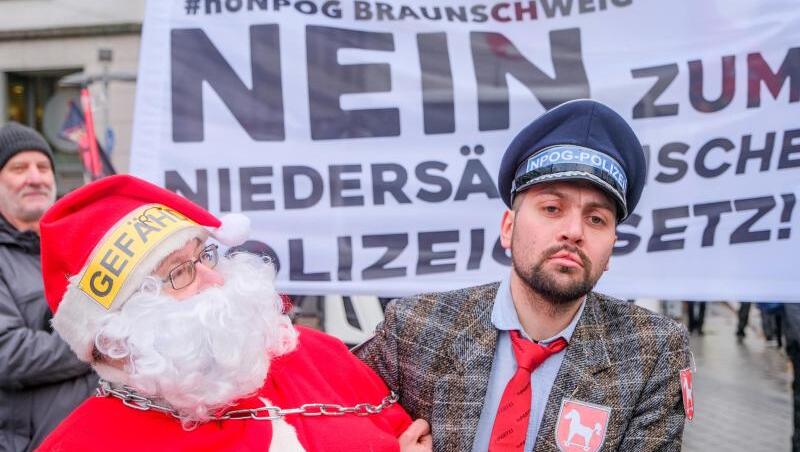 Als Weihnachtsmann und Polizist verkleidet protestieren Teilnehmer des Demonstrationszug gegen das geplante niedersächsische Polizeigesetz. Als Weihnachtsmann und Polizist verkleidet protestieren Teilnehmer des Demonstrationszug gegen das geplante niedersächsische Polizeigesetz.