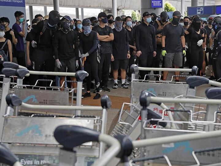 Demonstranten blockieren eine Straße vor dem Hongkonger Flughafen.