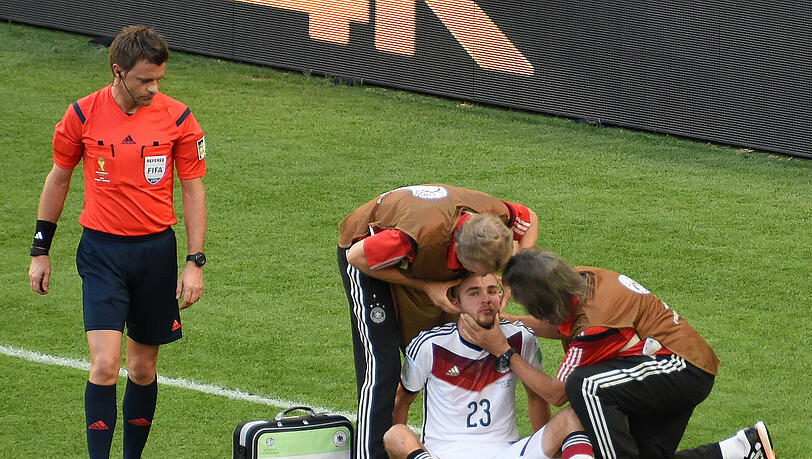 Christoph Kramer: ausgeknockt im WM-Finale. Links steht Schiedsrichter Nicola Rizzola. Christoph Kramer: ausgeknockt im WM-Finale. Links steht Schiedsrichter Nicola Rizzola.